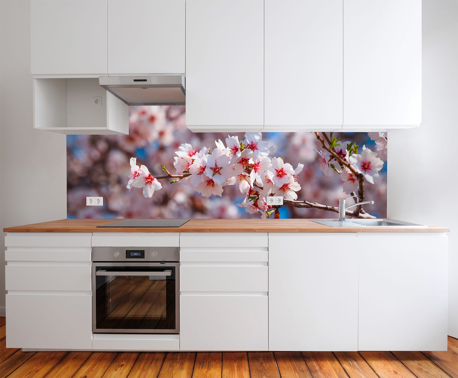 Küche mit weißen Schränken und Holzarbeitsplatte, im Hintergrund Kirschblüten auf einer Wand.